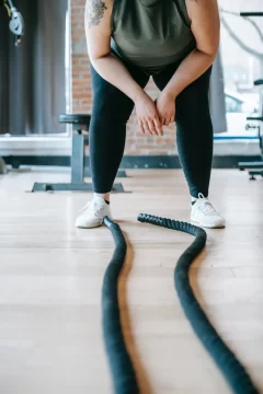 cuerdas de batalla y las piernas d euna chica cansada por sobreentrenamiento